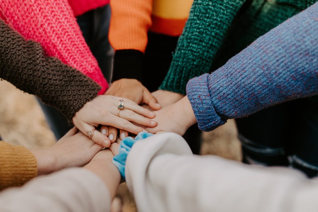 People touch hands while standing in a huddle: Barbara is involved in a restorative justice circle in North Bay