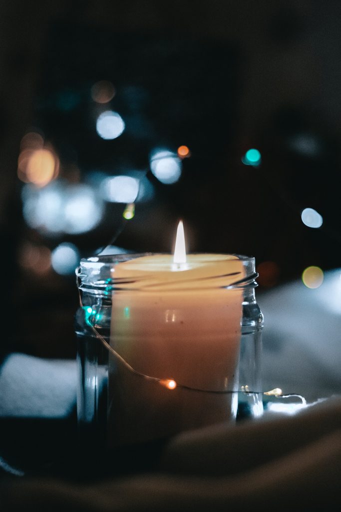Mindfulness and meditation: a lit candle on a tranquil dark background.